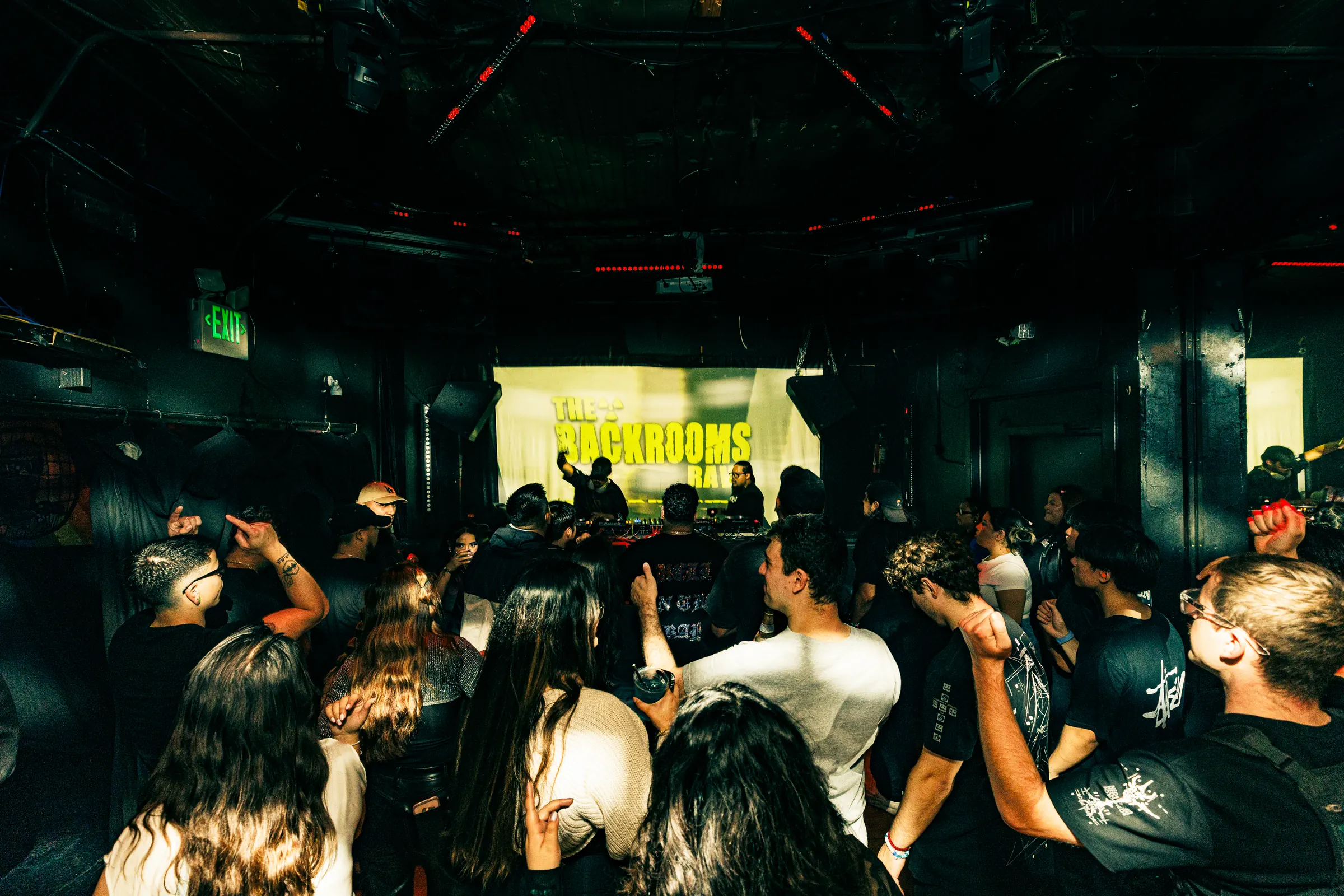 Crowd facing the DJ booth at The Backrooms Rave